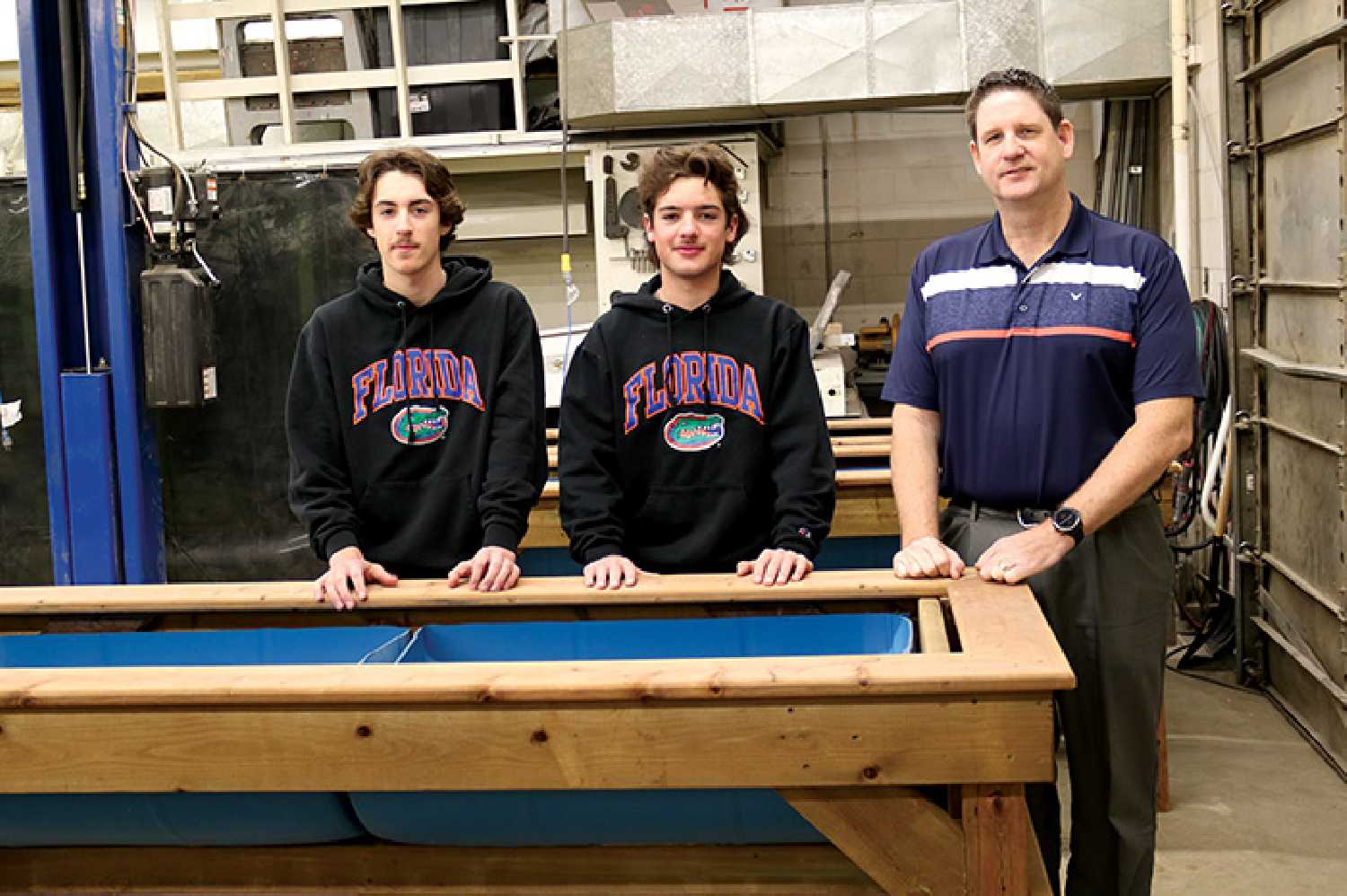 Grade 12 students Porter Skulmoski and Zayn Leslie, and Councillor Murray Gray beside raised planter boxes the students made for Moosomin’s community garden.
